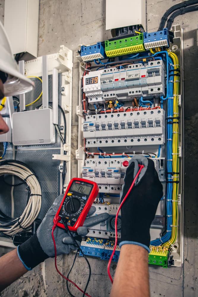 Technician validating wiring values with meter equipment