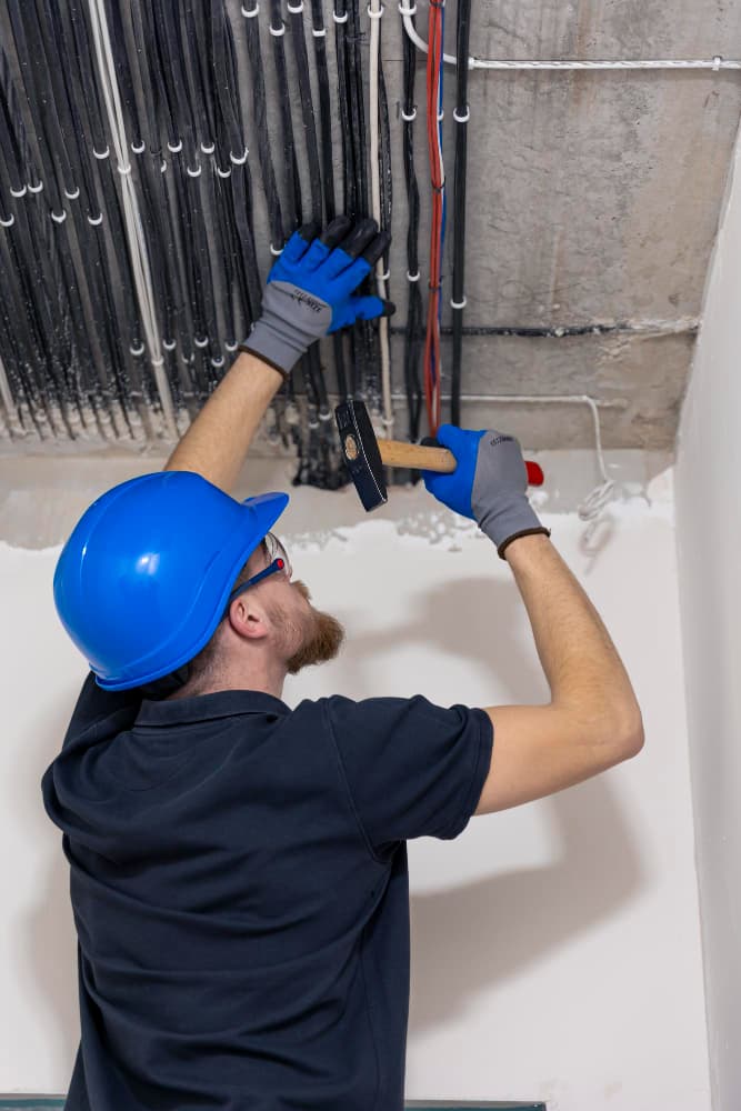 Technician working on wiring near electrical equipment