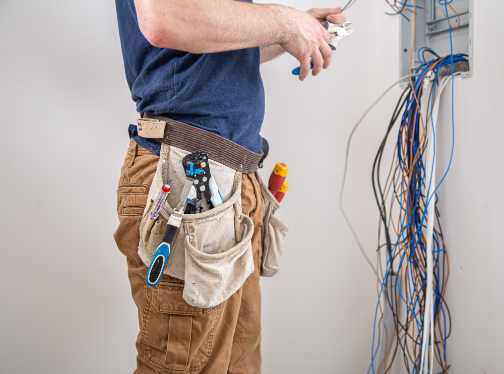 Technician testing an electrical outlet with a handheld tool